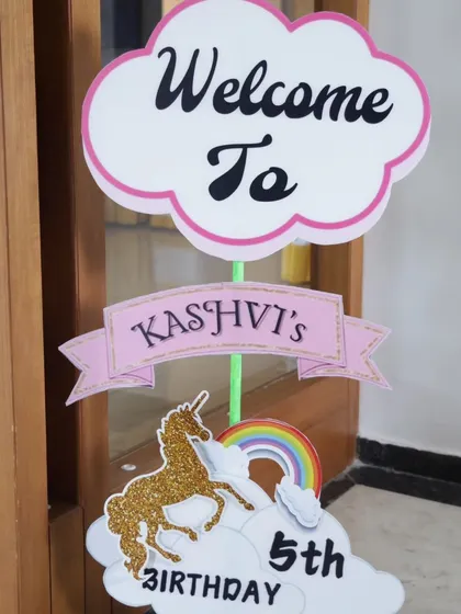 A custom welcome sign for a 5th birthday party with a glittery gold unicorn and rainbow graphic.