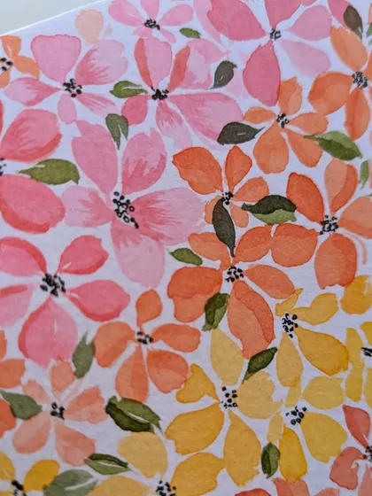 A detailed close-up of the watercolor floral pattern. Notice the subtle variations in color and the small green leaves tucked between the blossoms.