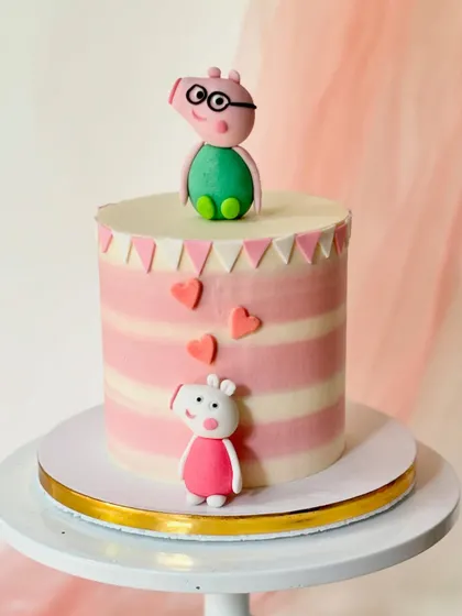 A clean and modern Peppa Pig cake with Daddy Pig and Peppa figures. The pink striped buttercream and little hearts create a simple yet charming design for a young fan's celebration.