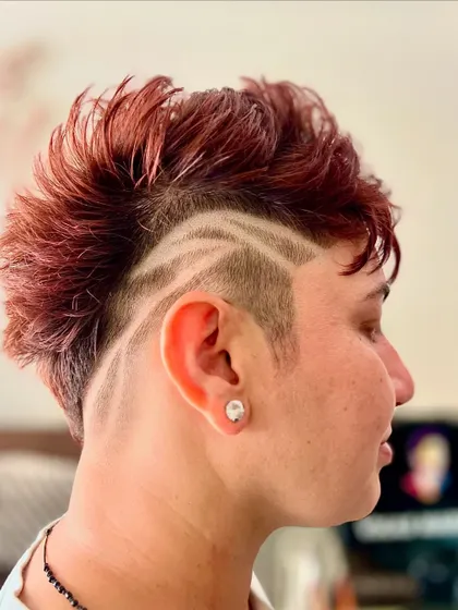 Hair is a canvas for art. This creative hair tattoo, combined with a textured mohawk and rich color, shows how we can push boundaries to create a look that is truly unique and expressive.