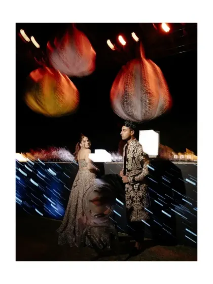 A creative, motion-blurred shot of the couple at the art-themed sangeet. This captures the dynamic and vibrant energy of the night, with the pumpkin lanterns glowing above.