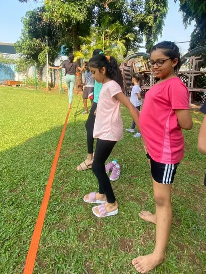 A group of our young female players waiting their turn for slackline training. We believe in making fitness activities fun and engaging for everyone.