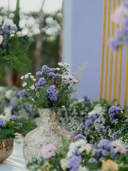 A collection of pastel floral arrangements in textured golden vases, perfect for adding detailed beauty to a modern event.