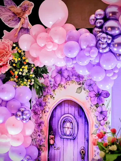 A magical detail shot of a purple fairy door surrounded by a stunning balloon and floral arrangement.