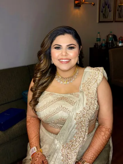 A reception bride in a beautiful golden gown. The makeup is soft and luminous, with a focus on a radiant complexion.