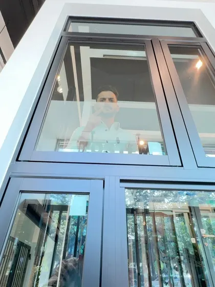 Here I am, looking through a Tostem window. The clarity of the glass and the slimness of the frame are what give these windows a modern and elegant look. They are designed to maximize your view while providing excellent insulation and security, a perfect combination for contemporary Indian homes.