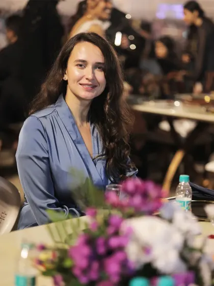 A smiling guest at her table, surrounded by flowers. This image captures the pleasant and beautiful atmosphere we help create at our events.
