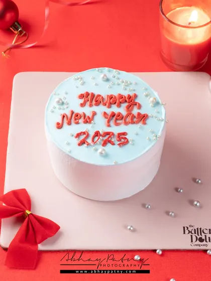 For this New Year's cake, I created a festive scene with ornaments and a red background. The styling is simple to keep the focus on the cake and its celebratory message.