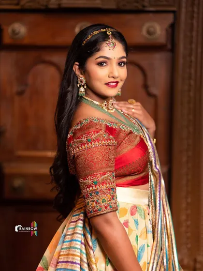 This image highlights the intricate embroidery on the sleeve of the red blouse, part of the multi-color half saree set.