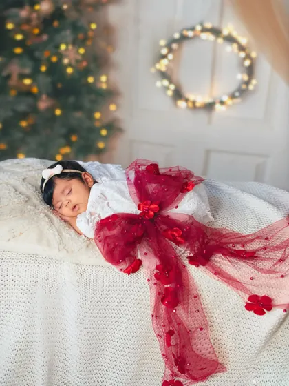 The most precious gift of all. This two-month-old is wrapped up like a Christmas present, a creative and adorable concept for a holiday milestone session.
