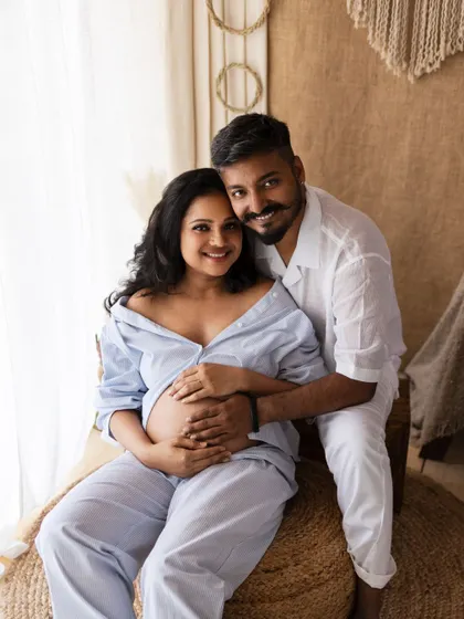 A happy and bright portrait of an expecting couple. Their smiles and the warm lighting make this a joyful and heartwarming image.