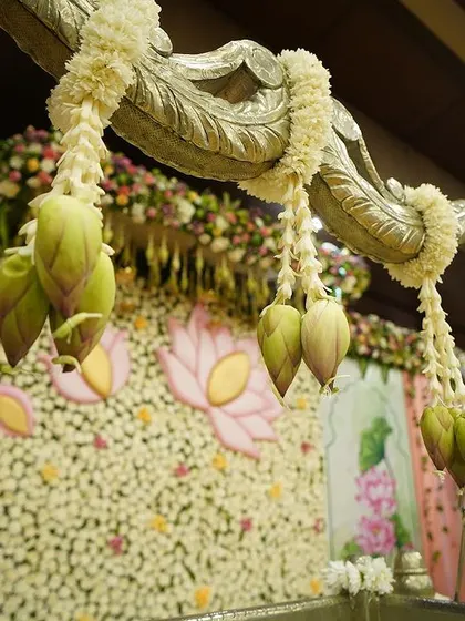 My eye for detail is crucial in creating thoughtful decor. Here, hanging lotus buds and a floral wall with custom lotus cutouts add layers of beauty and symbolism to a traditional cradle ceremony.