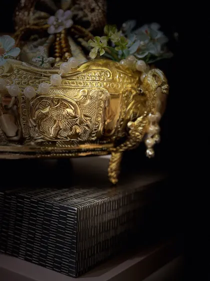 A dramatic shot of our intricately carved golden bowl. This piece is perfect for luxury festive gifting and adds a touch of opulence to any home decor.