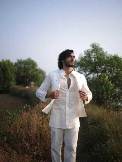 A full-length shot of Vishak Nair's premiere outfit. The white-on-white ensemble with subtle embroidery on the jacket and cuffs offers a fresh, modern take on men's formal ethnic wear.