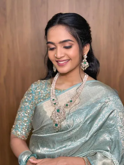 A smiling, eyes-closed shot that shows the delicate eye makeup.