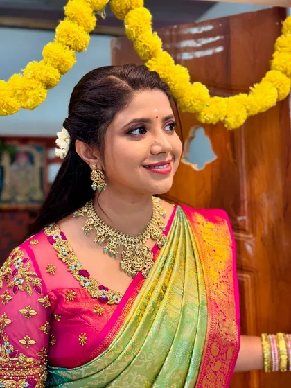 A close-up of Swetha Khelge, showing the detail of the necklace and matching earrings.