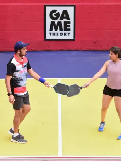 A moment of sportsmanship as two mixed doubles players tap paddles between points. It's competitive, but always friendly.