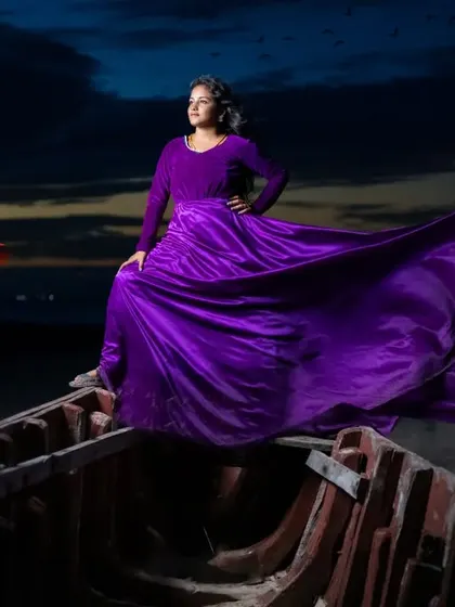 This dramatic shot on a boat at dusk shows the full potential of the purple gown's flowing satin skirt. It's an epic look for a creative pre-wedding photoshoot.