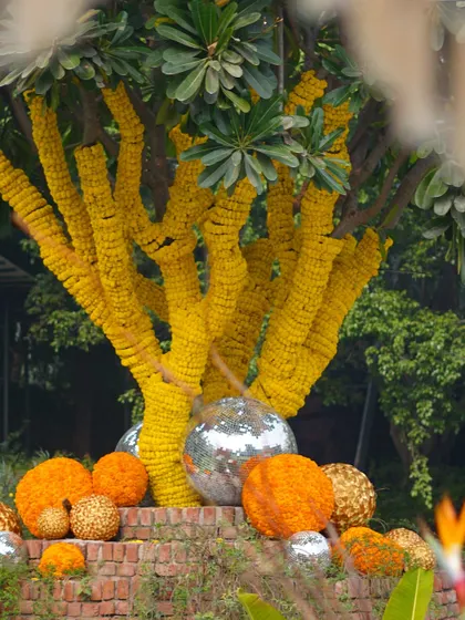 A tree wrapped in marigolds, with disco balls adding a touch of modern fun to the traditional decor.