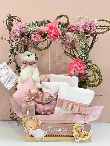 A beautiful and dreamy hamper to welcome baby Dirahyaa. Designed in soft pinks, it features a floral arch, a cuddly teddy bear, and elegantly wrapped gifts, creating a magical welcome for a little princess.