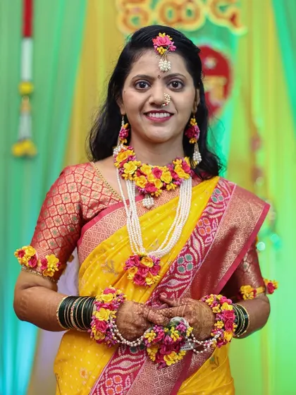The bride posing happily in her yellow Haldi attire.