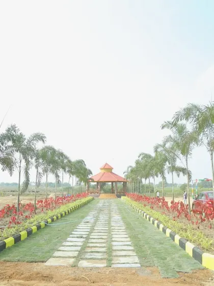 A new development or layout featuring a long pathway lined with young trees and a children's play area in the background. This showcases my work in creating complete community infrastructure.