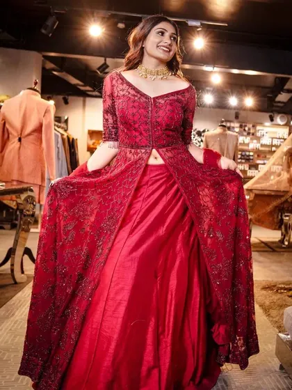 A moment of pure joy and elegance. This shot captures the model in a beautiful red gown, showcasing its flow and intricate design within a luxury retail environment.