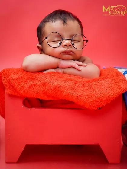 This little one looks so peaceful and smart with his tiny round glasses. Themed shoots are a wonderful way to add a unique story to your baby's first photos.