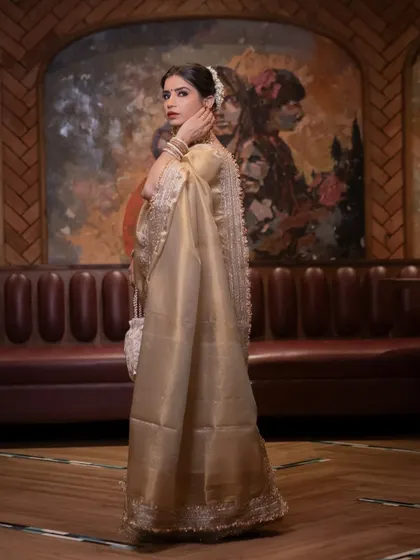 A full-length shot capturing the grace and elegance of the golden Kanjeevaram tissue saree.