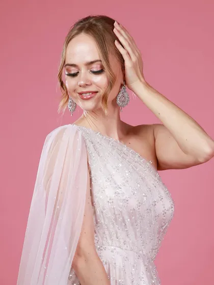 A delicate portrait of Irina Rudakova with her eyes closed, showcasing the detailed makeup and the texture of her elegant white gown.