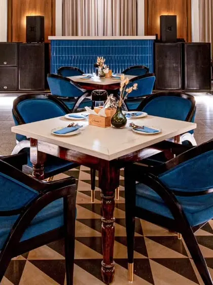 A focused shot on a central table setting at Vamos Experience. The bold blue chairs and geometric patterns create a strong focal point, demonstrating how I capture specific design stories within a larger space.