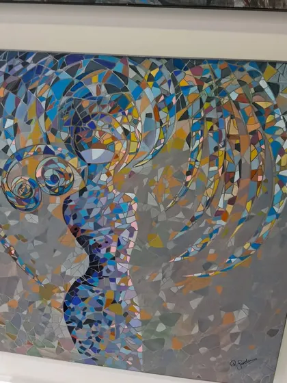 A mosaic piece showing a woman's silhouette against a colorful, fragmented background, demonstrating a modern approach to this ancient art form.