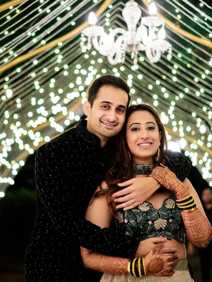 A romantic portrait of the couple at their Sangeet in Lonavala, set against a beautiful backdrop of fairy lights.