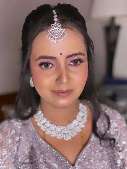 A dreamy reception look in a lavender lehenga. The makeup features soft pink and purple eyeshadow with a subtle lip, paired with diamond jewelry for a touch of sparkle.