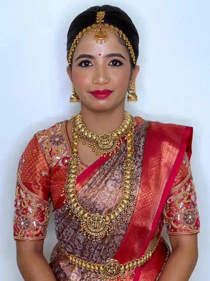 A front-facing shot that captures the bride's radiant smile and the flawless finish of her bridal makeup.