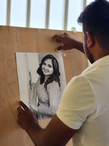 Me placing the finished portrait on my drawing board.