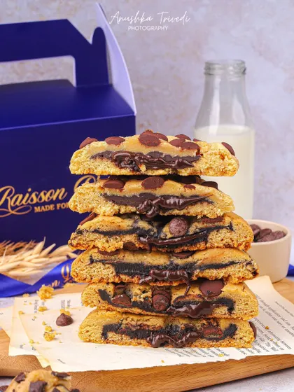 A stack of chocolate-filled cookies, cut in half to reveal the gooey, melted center.