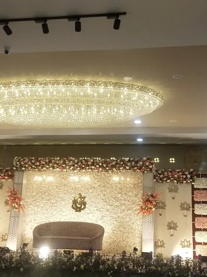This image captures the entire reception hall, showing how the grand stage and the overhead chandelier work together to create a luxurious ambiance.