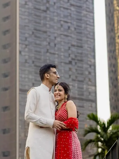 An urban-style couple portrait. The modern architecture in the background provides a unique contrast to the couple's traditional Indian attire.