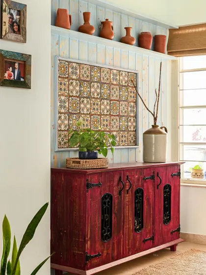 A custom-made, distressed vintage shoe unit sits in the foyer against a wood-paneled wall with antique-finish Moroccan tiles.