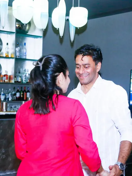 A happy couple looking at each other as they dance. The bar lights in the background add to the club atmosphere.