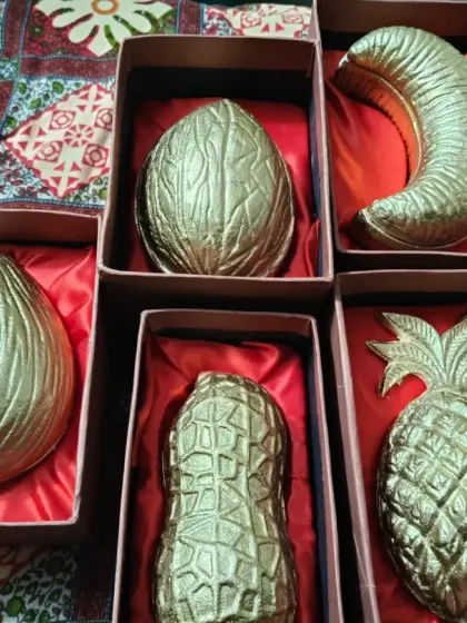 A variety of my fruit and nut-shaped urli candles, including coconut, banana, peanut, and pineapple, packed in satin-lined gift boxes.