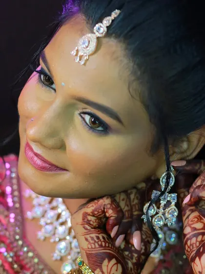 A close-up of a bride adjusting her earring, a classic getting-ready shot.