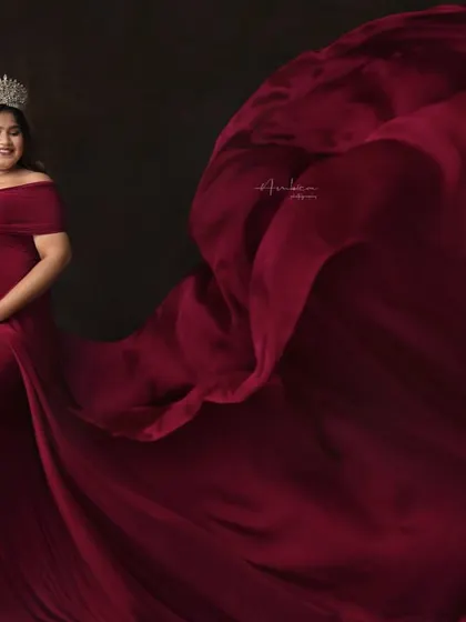 Every mother is a queen. This dramatic studio portrait features a flowing red gown tossed to create a sense of movement and grandeur. The crown adds a final touch of royalty.