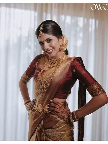 A playful and confident pose from the bride, showing off her stunning wedding attire and beautiful smile.