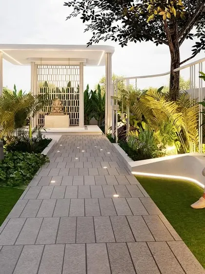 A modern mandir is the focal point of this serene garden, accessed by a clean, paved pathway with integrated lighting. The design blends spirituality with contemporary landscape architecture, offering residents a peaceful space for reflection.
