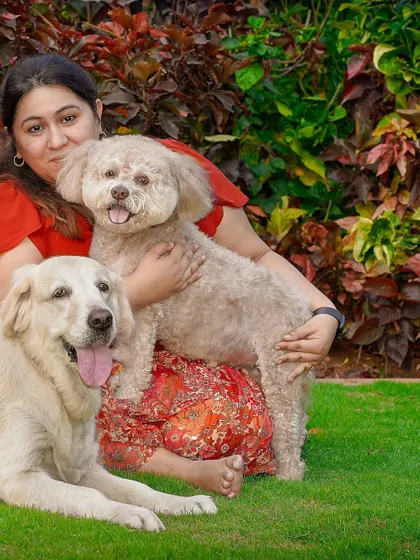 A slightly different angle of the woman and her two dogs, capturing their relaxed and happy expressions.