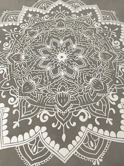 An angled view of the white mandala, showing how the light catches the symmetrical patterns.