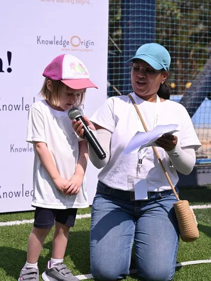 A teacher helps a student take the sportsmanship oath at the start of the meet.