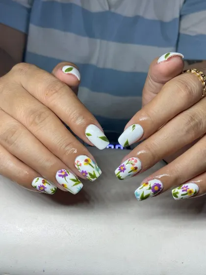 A matte white base with delicate, hand-painted wildflowers. This 'meadow nails' look is artistic and perfect for spring.